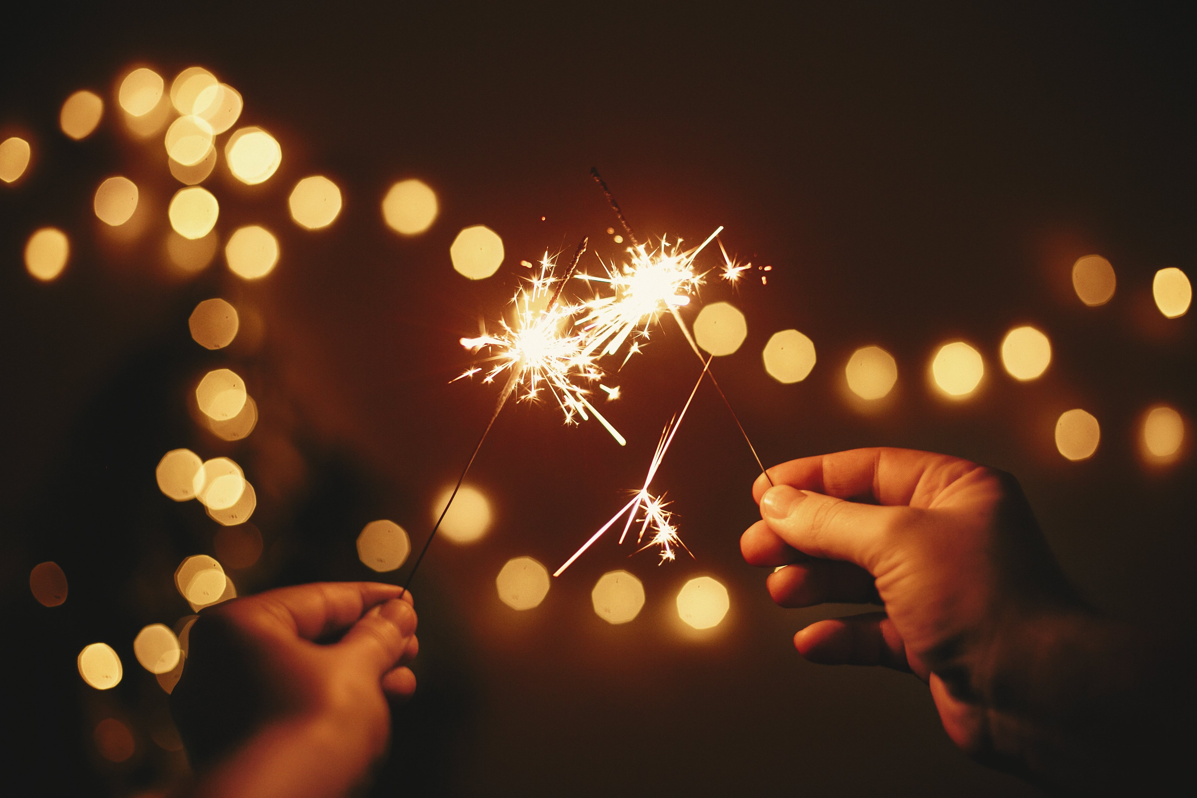 glowing-sparklers-in-hands-on-background-of-golden-2025-03-15-23-04-17-utc